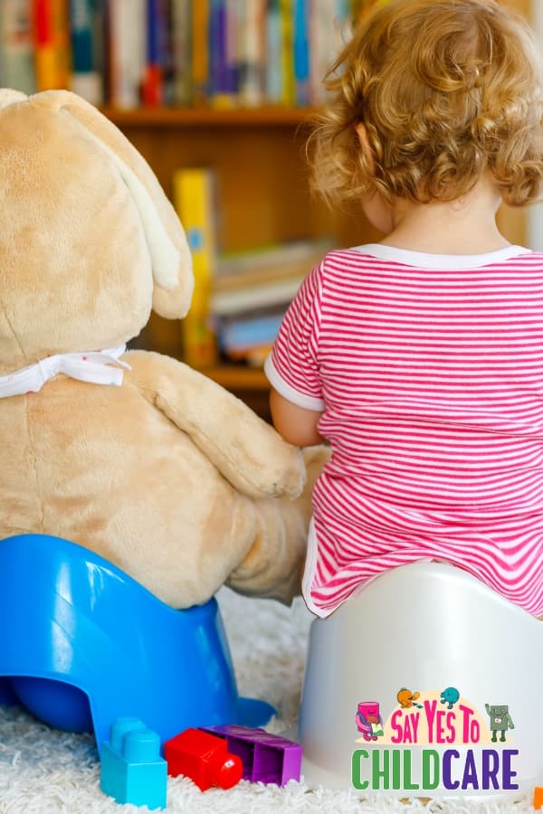 child sitting on potty with stuffy